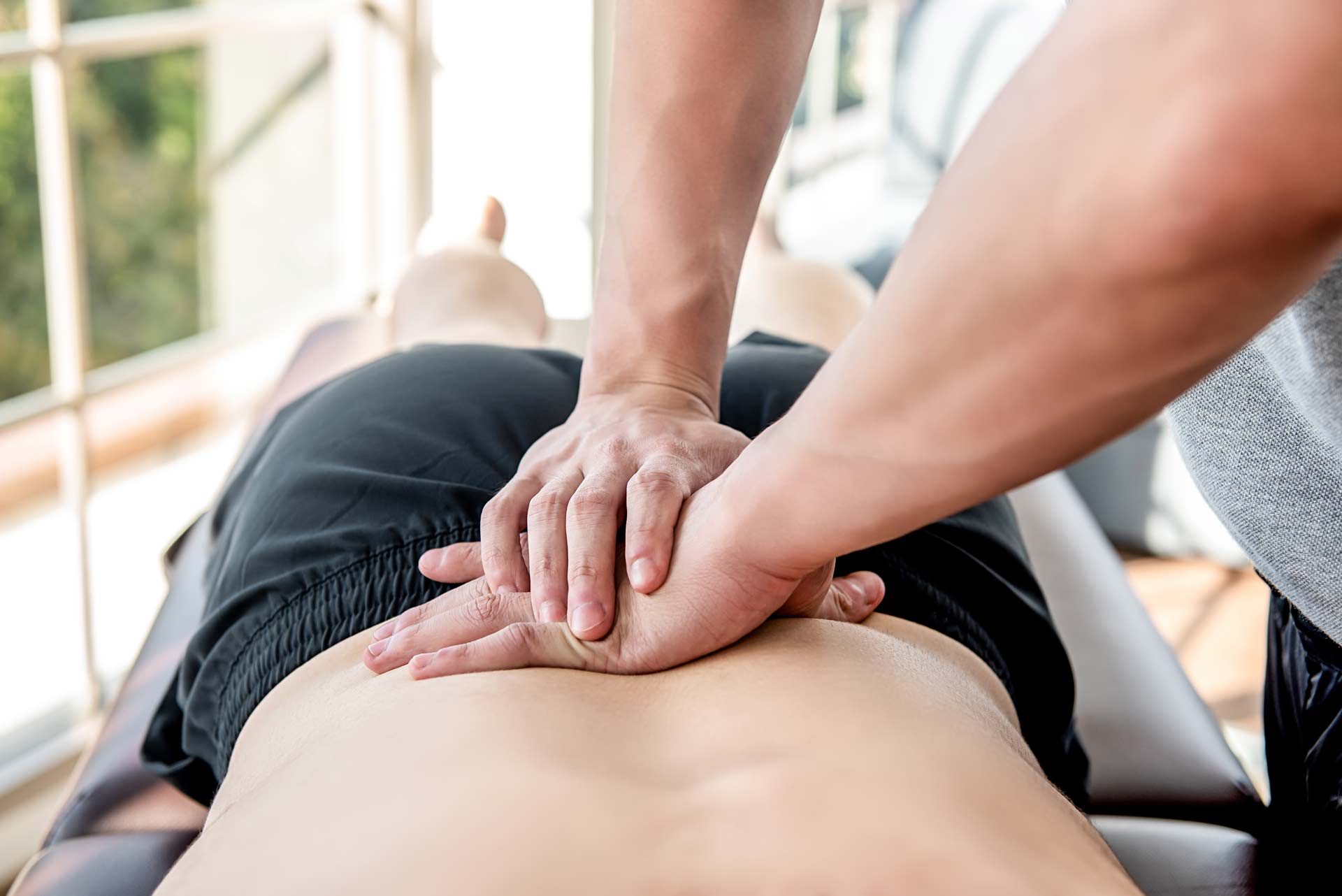 doctor applying pressure to a patients lower back