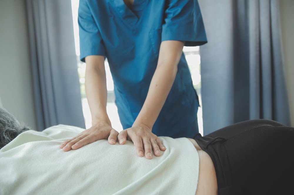 doctor putting pressure on patients back
